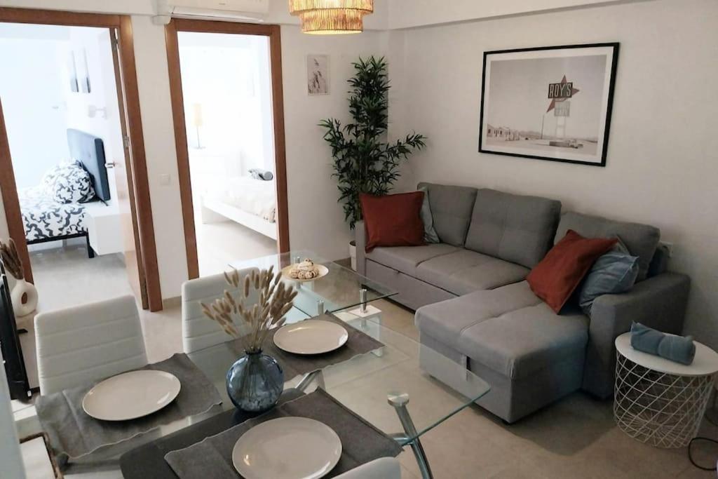 sala de estar con sofá y mesa en Veguita 2: piso renovado a 3 min de la playa, en Almería