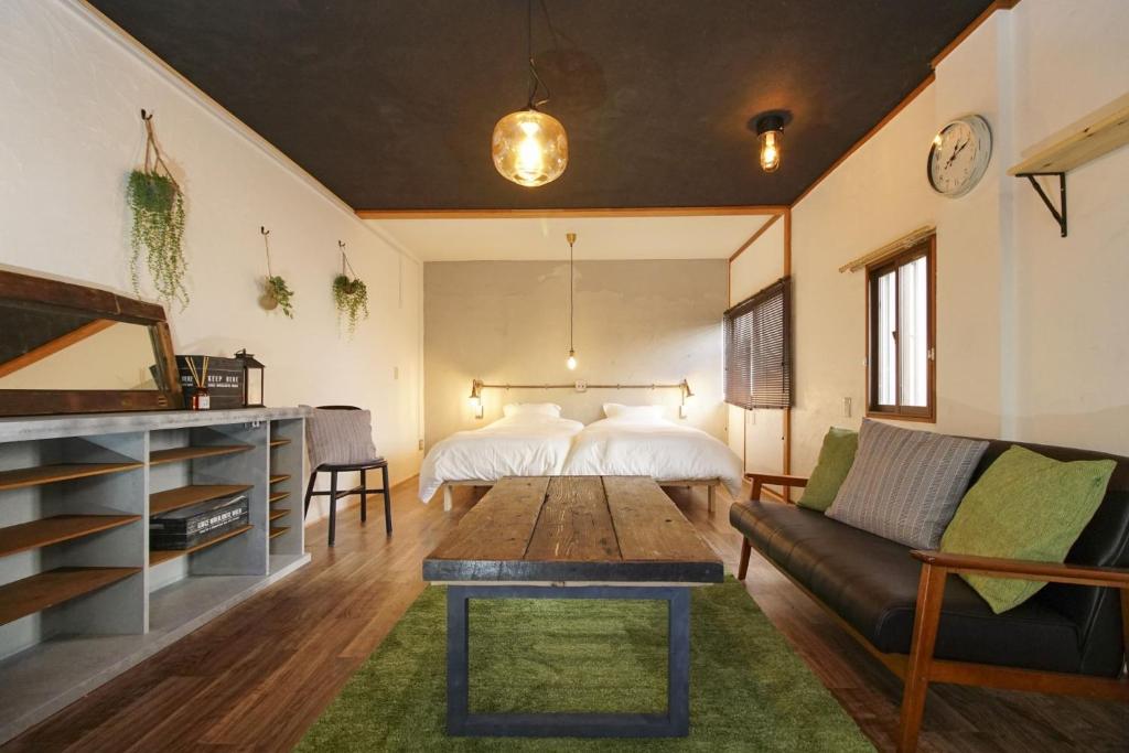 uma sala de estar com um sofá e uma cama em Guesthouse Yumi to Ito - Vacation STAY 94562v em Nagano