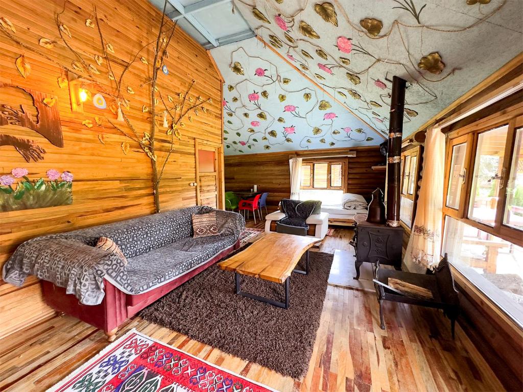 ein Wohnzimmer mit einem Sofa und einem Tisch in der Unterkunft Aynştayn Chalet in İznik