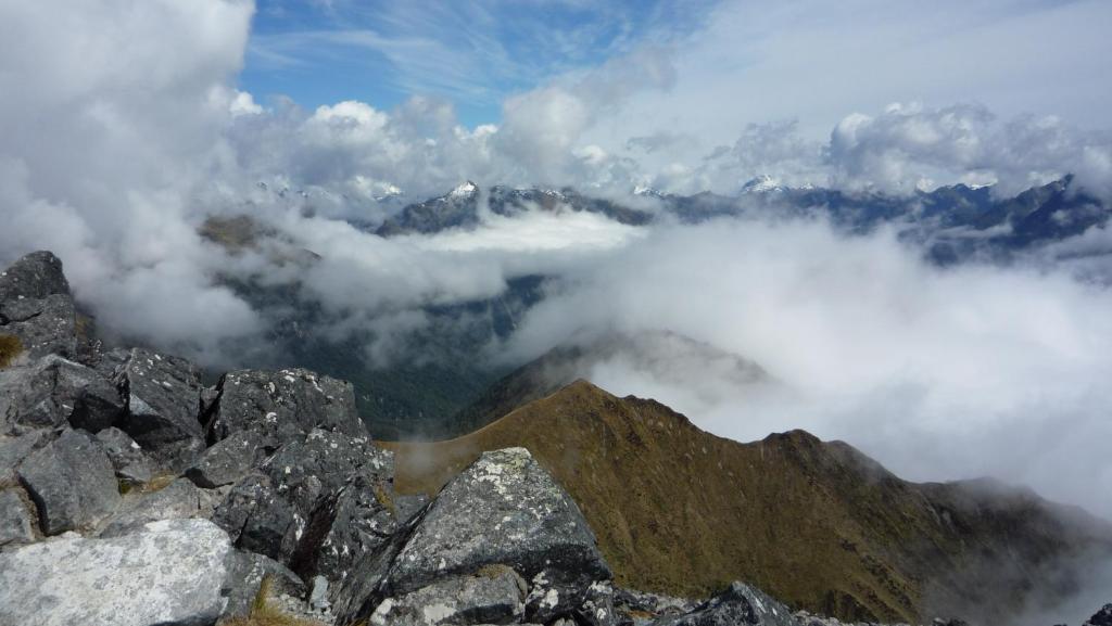 a view from the top of a mountain with clouds at Templenoe Paradise in Te Anau