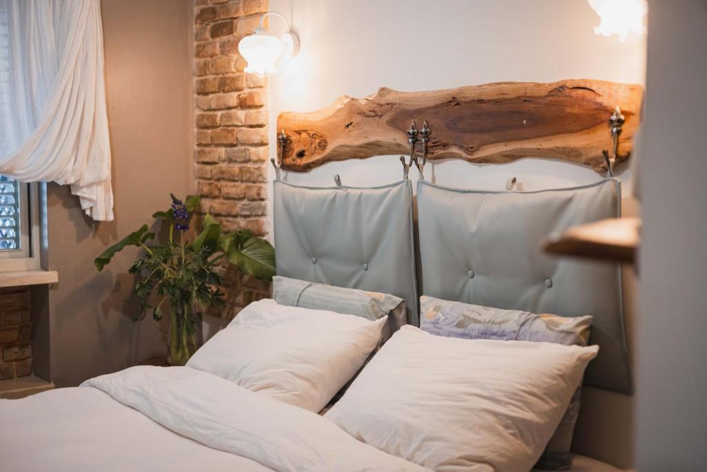 a bed with white pillows in a room at חלון לגלבוע צימר בוטיק בעמק המעיינות in Bet Alfa