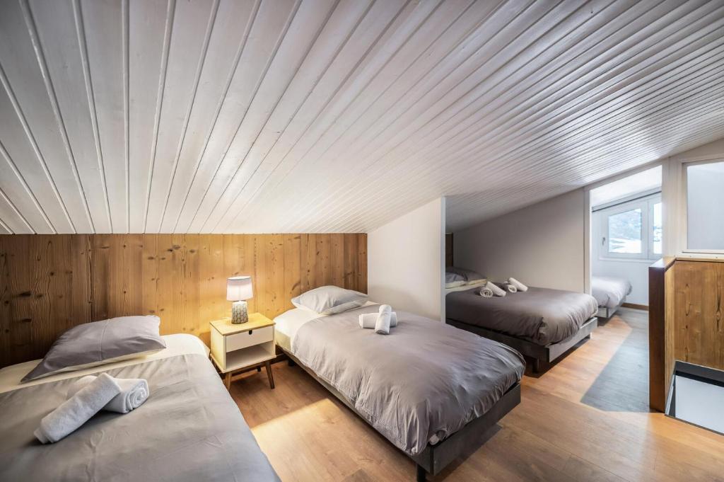 1 dormitorio con 2 camas y techo de madera en Résidence La Roche Blanche - 3 Pièces pour 6 Personnes 264, en Val Thorens