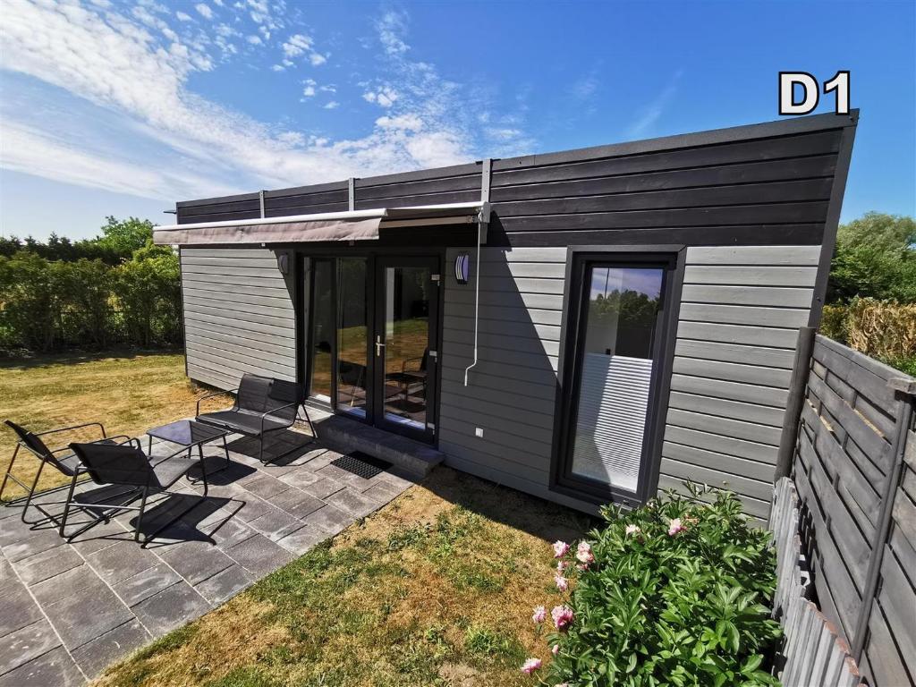 a black and white shed with two chairs and a patio at DM DOMKI Kościelna 54 in Mielno