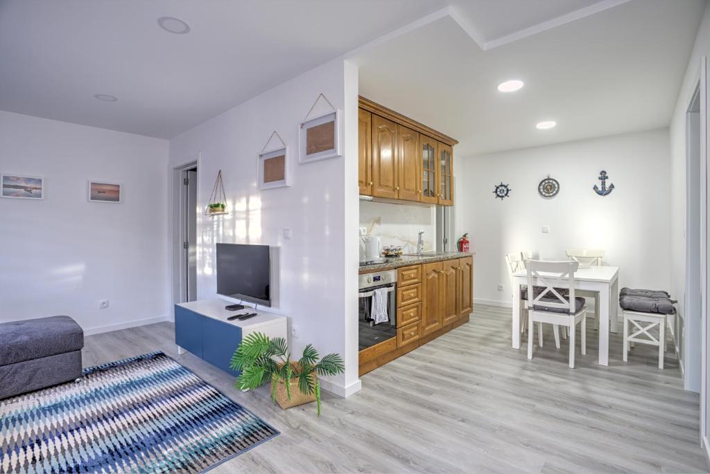 a living room with a kitchen and a dining room at Cantinho a Sul II - Costa Nova in Gafanha da Encarnação