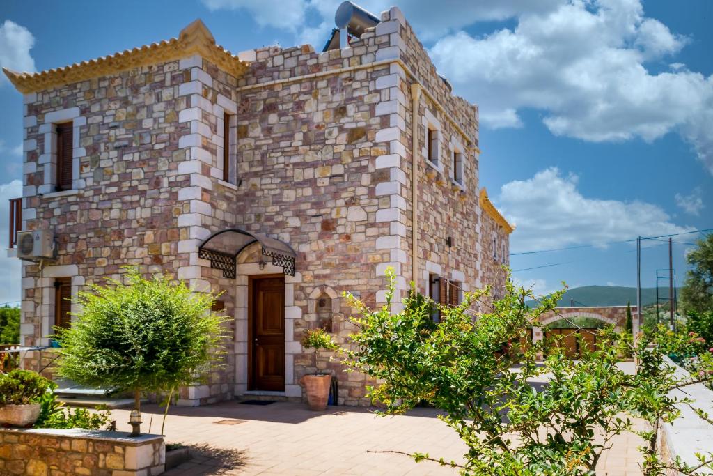 a large stone building with a wooden door at LIOKRINA country living villas & suites in Koroni