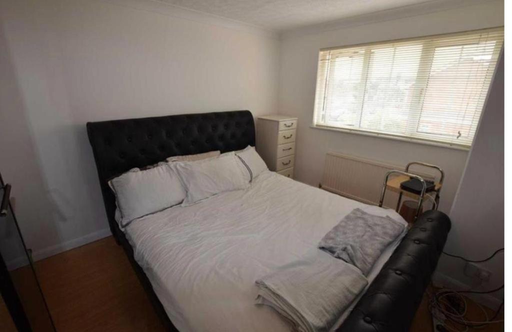 a bed with a black headboard in a bedroom at 8 Warren close Stanford-Le-Hope in Stanford-le-Hope