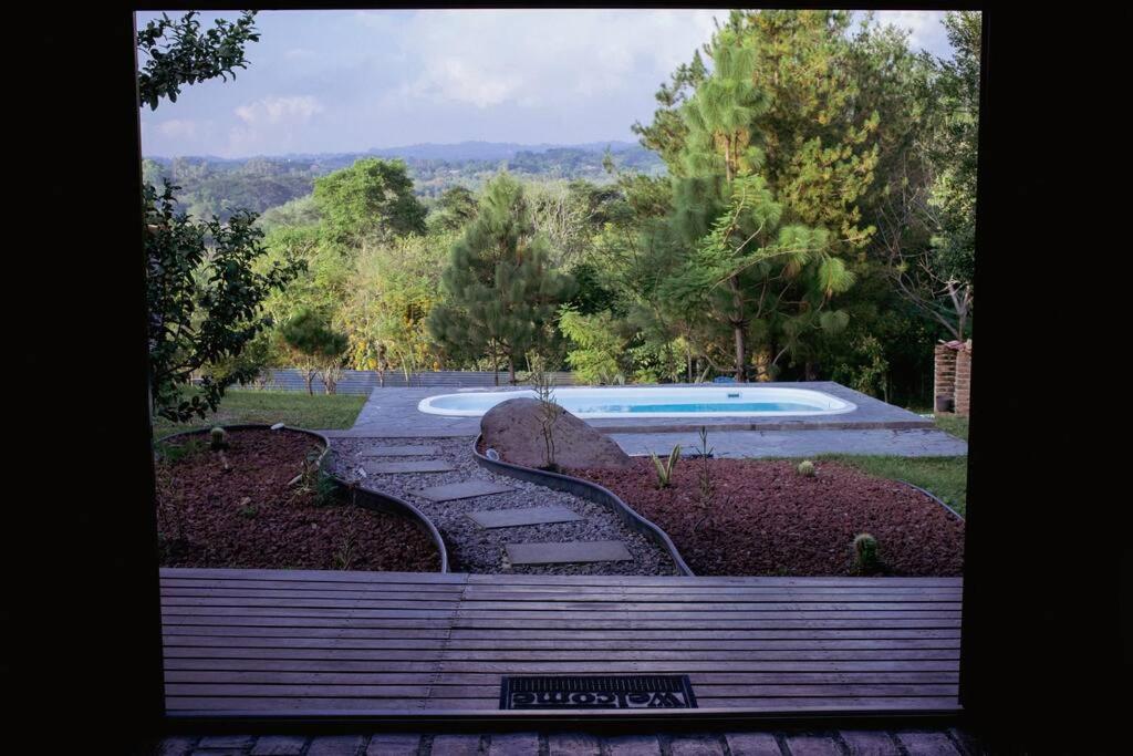 コリマにあるcabaña las chachalacas,hermoso espacio naturalのスイミングプール付きの庭園の景色を望めます。