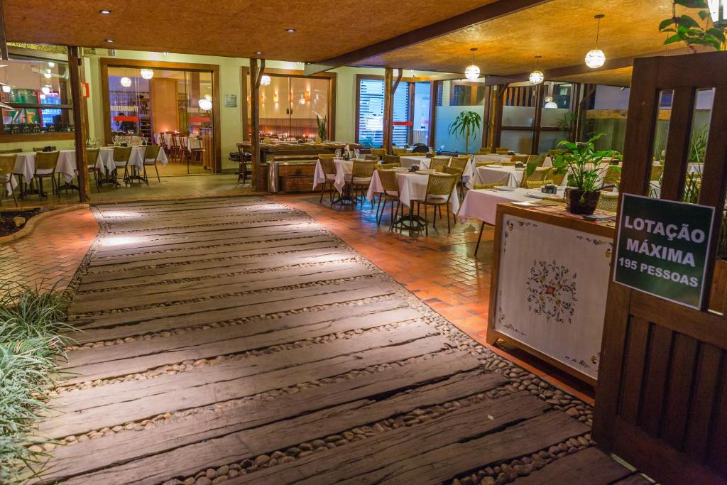 una sala da pranzo con tavoli e sedie in un ristorante di Hotel Bandeirantes a Cachoeira do Campo