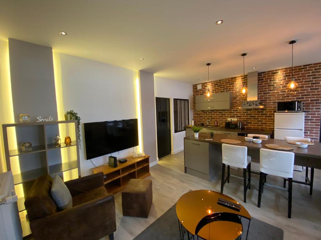eine Küche und ein Wohnzimmer mit einem Sofa und einem Tisch in der Unterkunft Le petit Brooklyn in Straßburg