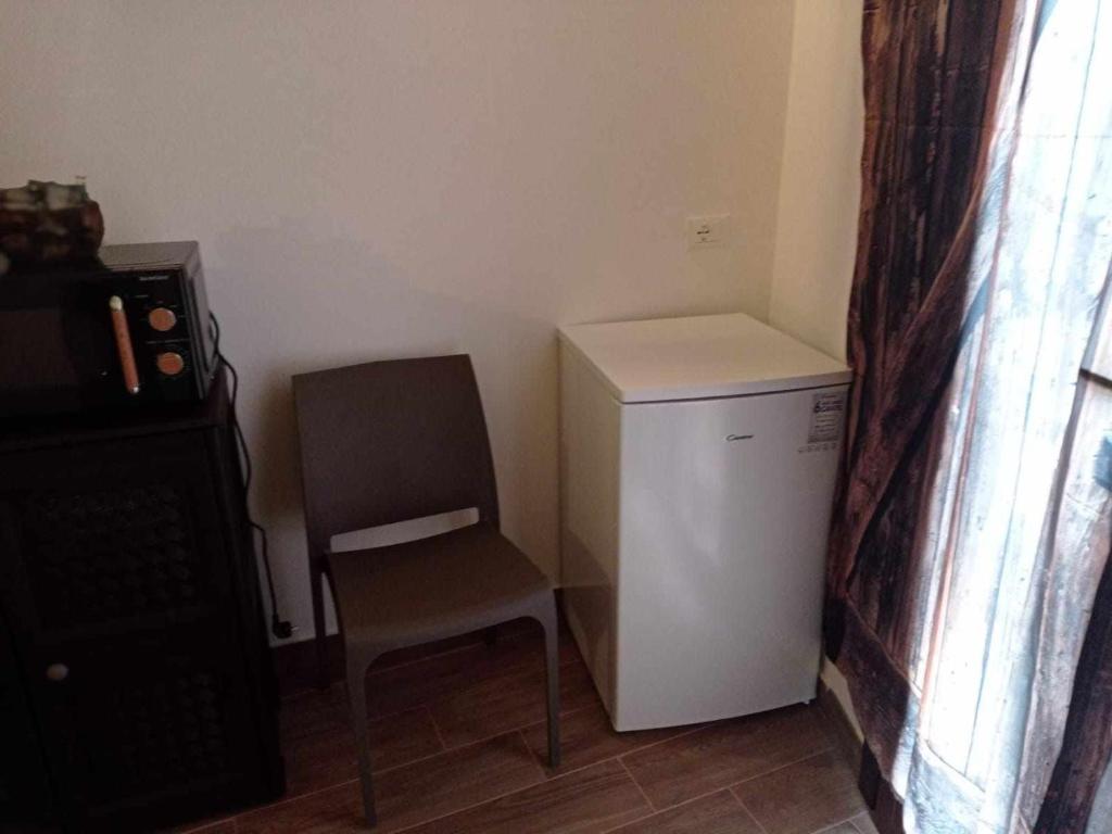 a small white refrigerator and a chair in a room at casa vacanze pupo 2.0 in Favignana