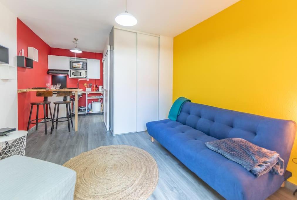 - un salon avec un canapé bleu et un mur jaune dans l'établissement Chez vous à Evry, Évry-Courcouronnes