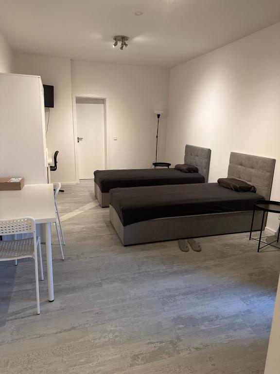 a room with two beds and a table and a chalkboard at Place to sleep - Kassel: Direkt an der Uni in Kassel
