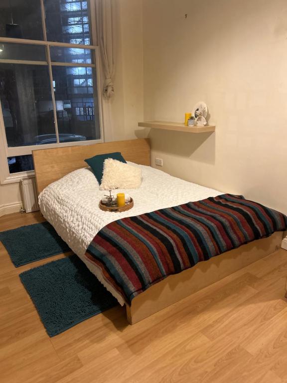 a bedroom with a bed with a tray of food on it at Comfy studio in London