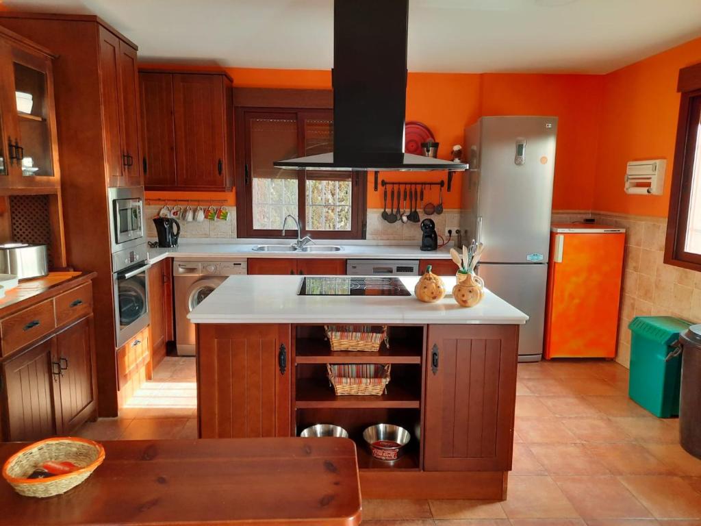 a kitchen with orange walls and a white counter top at Villatrajín in Otura