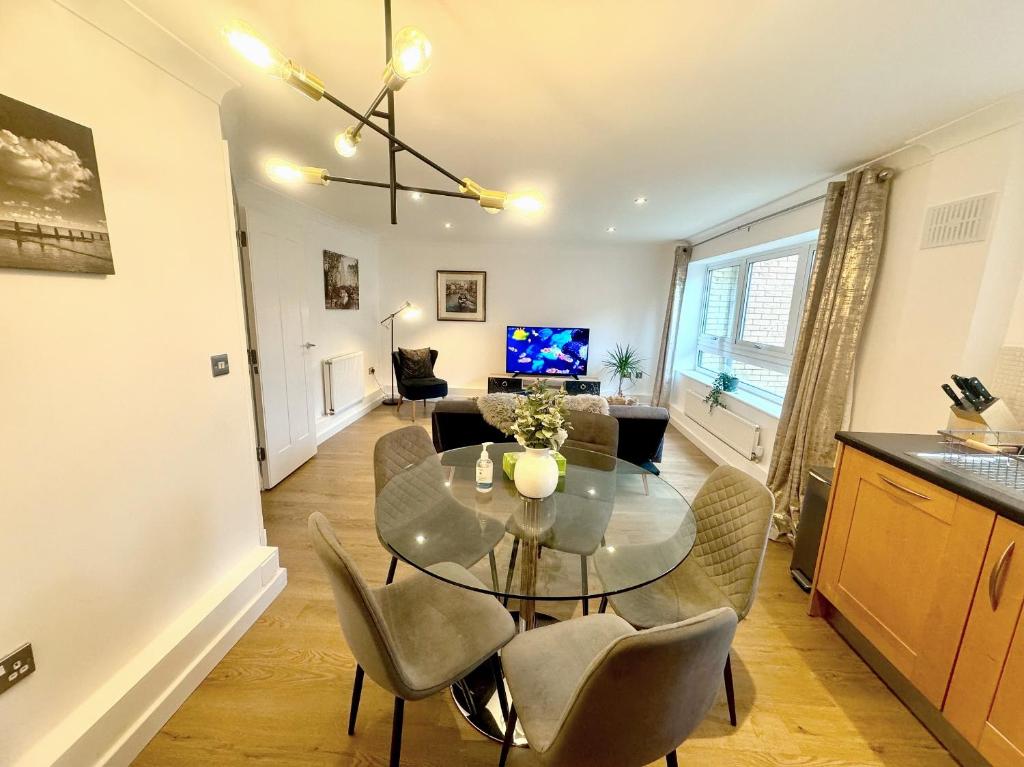 a dining room and living room with a table and chairs at Kiwi Tree Serviced Apartment in Cambridge