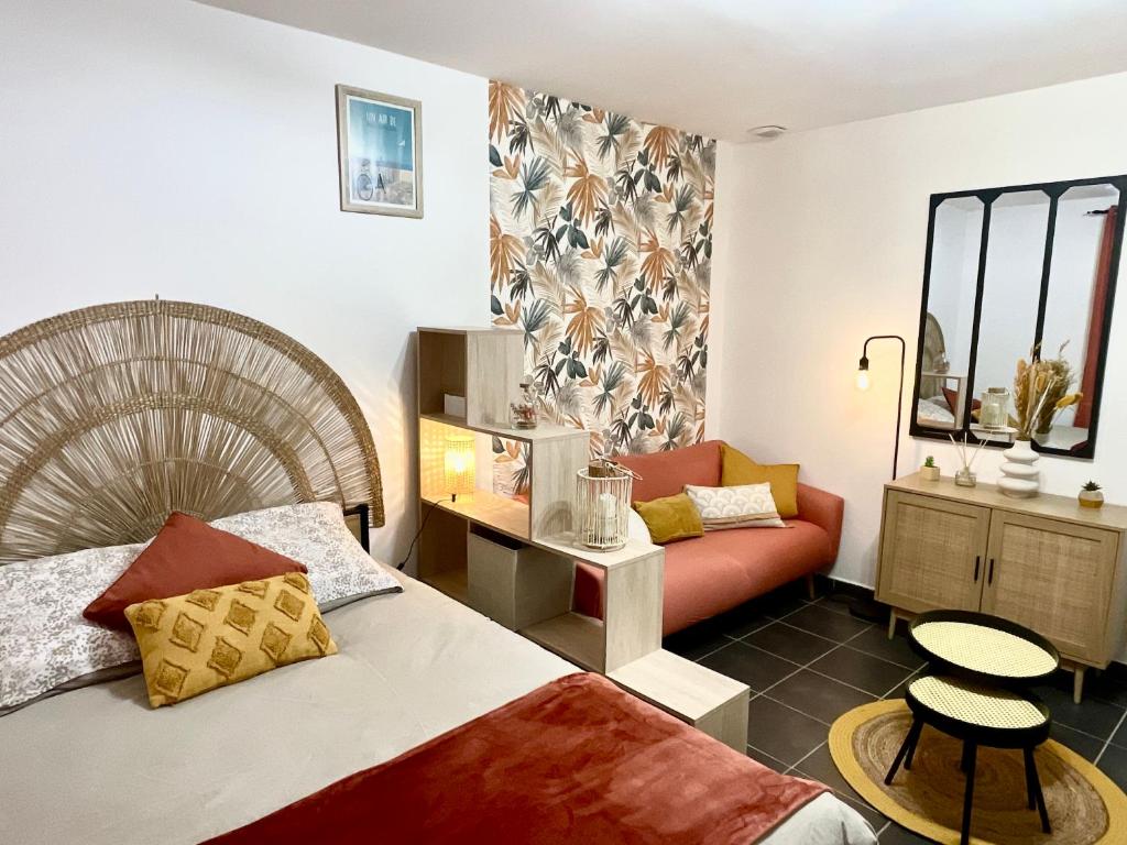a hotel room with a bed and a couch at L’émeraude - T2 en plein coeur de Dinan in Dinan