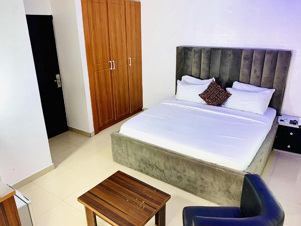 a small bedroom with a bed and a chair at Vintage Classic Hotel in Lagos