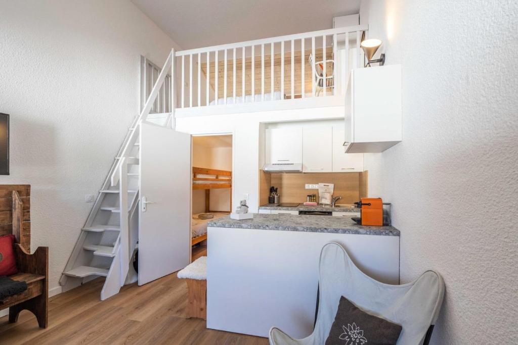 a kitchen with a counter and a staircase in a room at Résidence Les Horizons D&#39;huez - 2 Pièces pour 4 Personnes 724 in LʼHuez