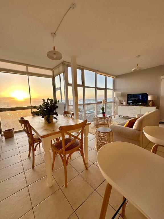 a living room with a view of the ocean at Charming beachfront Strand apartment in Cape Town