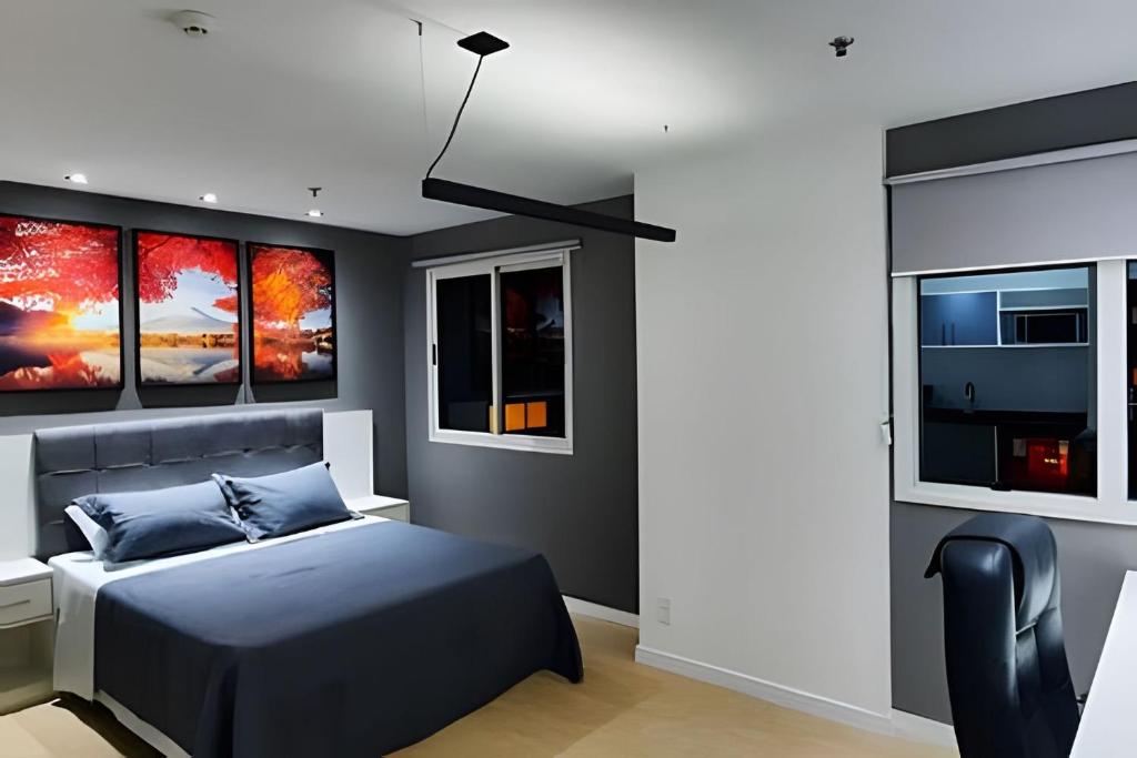 a bedroom with a bed and three windows at Paulista Premium Flat in São Paulo