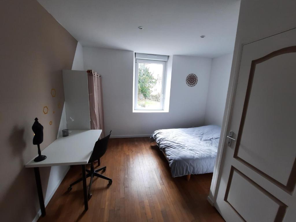sypialnia z łóżkiem, biurkiem i oknem w obiekcie Belle Suite privative centre vesoul w mieście Vesoul