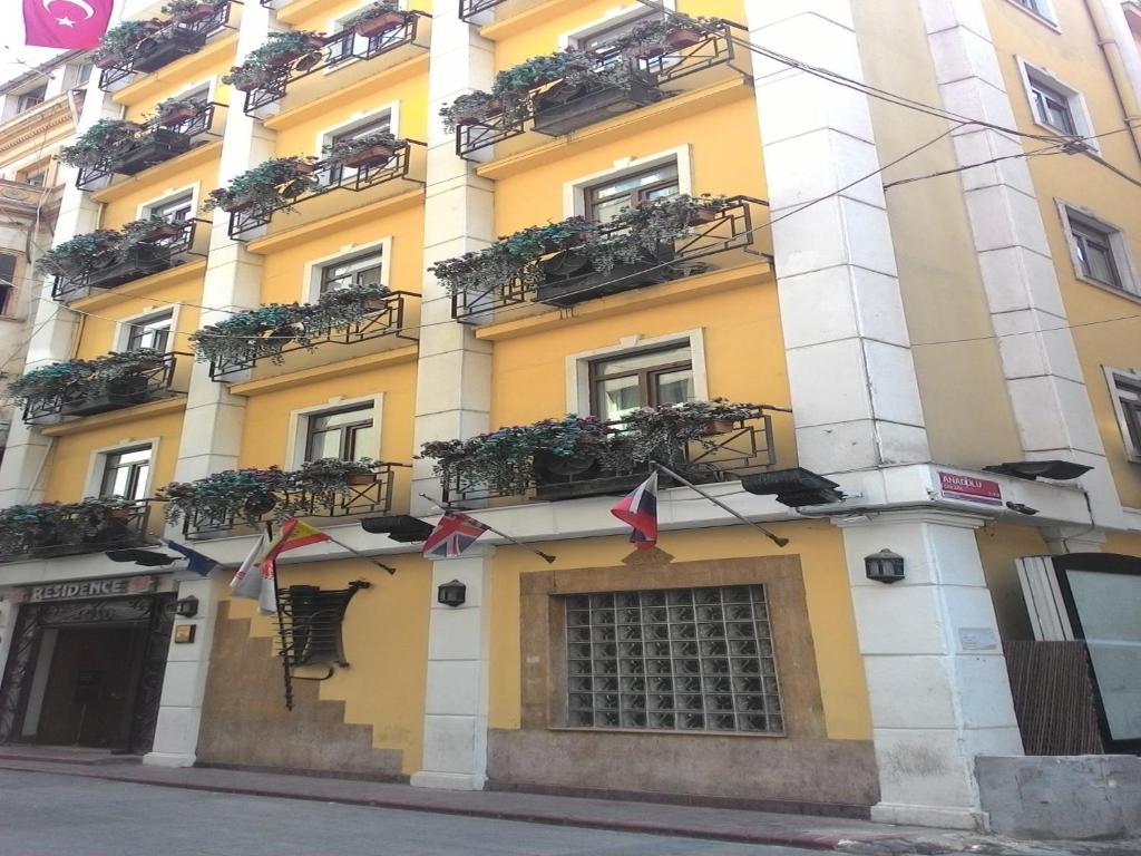 a yellow building with balconies and flags on a street at Hotel Residence in Istanbul
