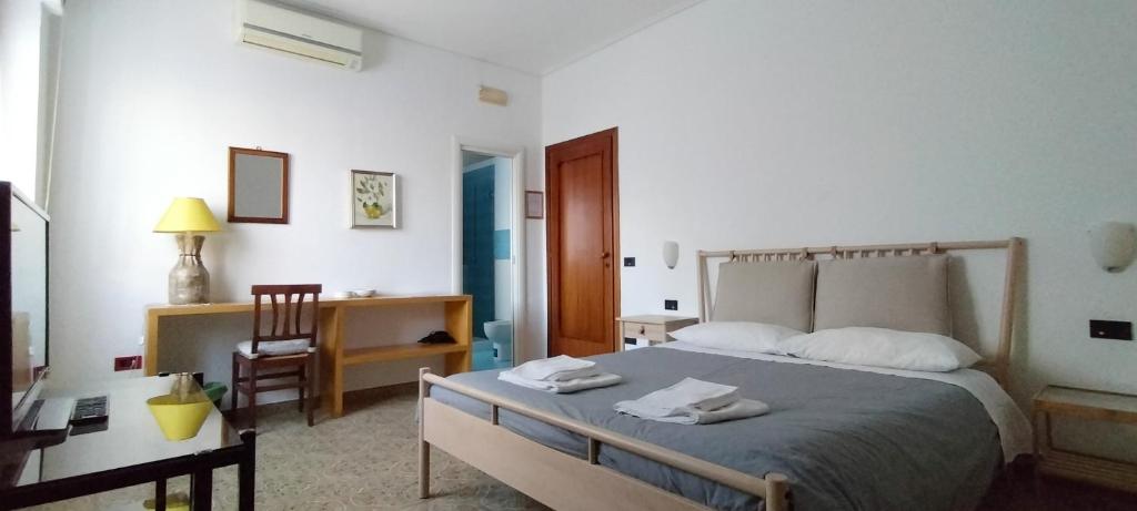 una camera con letto, scrivania e sedia di B&B Vanvitelli a Caserta
