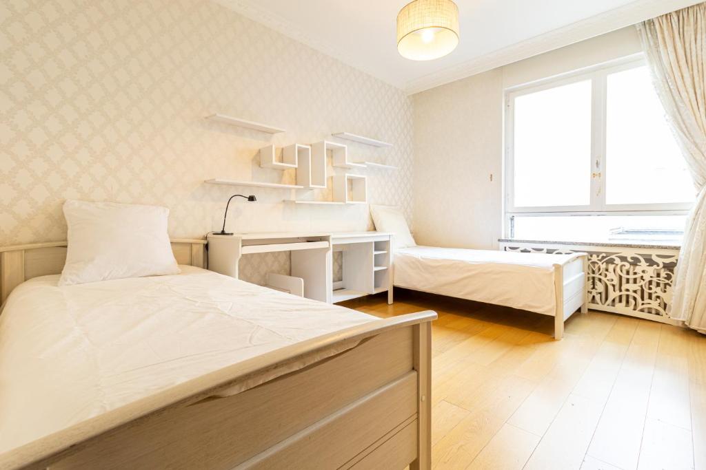 - une chambre avec 2 lits, un bureau et une fenêtre dans l'établissement Spacious flat 120m2 close to Eiffel Tower, à Paris