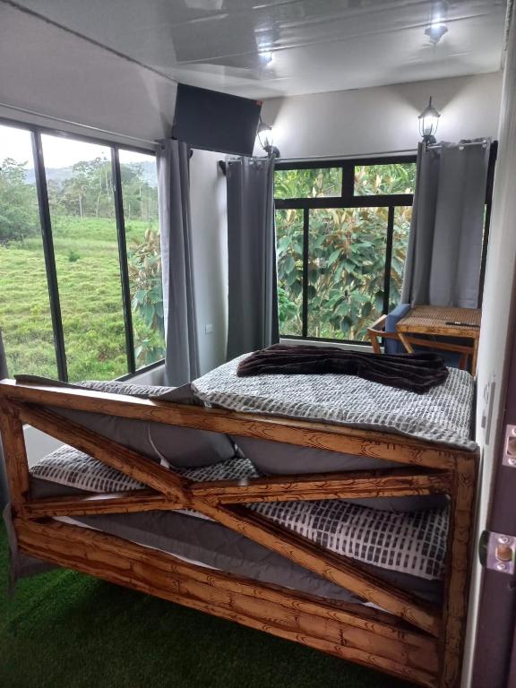 Hospedaje Nacho 2 في Los Chiles: غرفة نوم بسريرين بطابقين في غرفة بها نوافذ