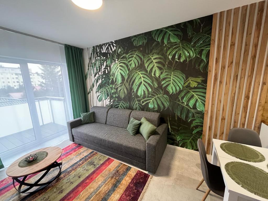a living room with a couch and a plant wall at Apartament Zacisze 13 in Piaseczno