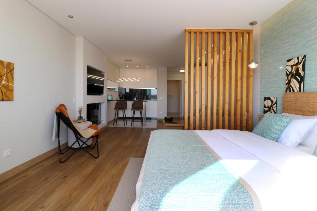 a bedroom with a large bed and a living room at Vilamoura Sunrise in Quarteira