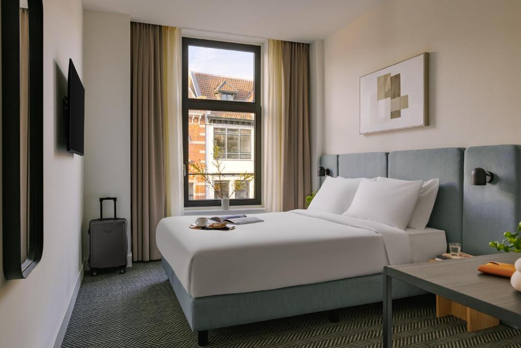 a hotel room with a bed and a window at Sonder Rose in Rotterdam