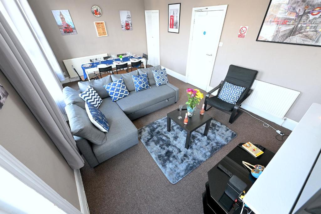 STUNNING 3 Bedroom Serviced Flat IN North London في لندن: إطلالة علوية لغرفة معيشة مع أريكة وطاولة