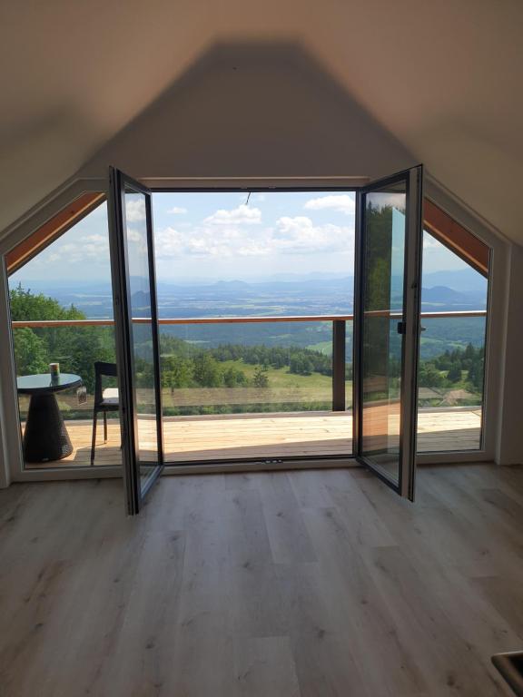 an open room with a large glass door at Koča z razgledom in Križe