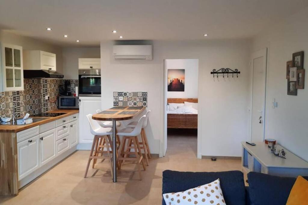 une cuisine et un salon avec une table et des chaises dans l'établissement Les clés de Bormes 40 m2, à Bormes-les-Mimosas
