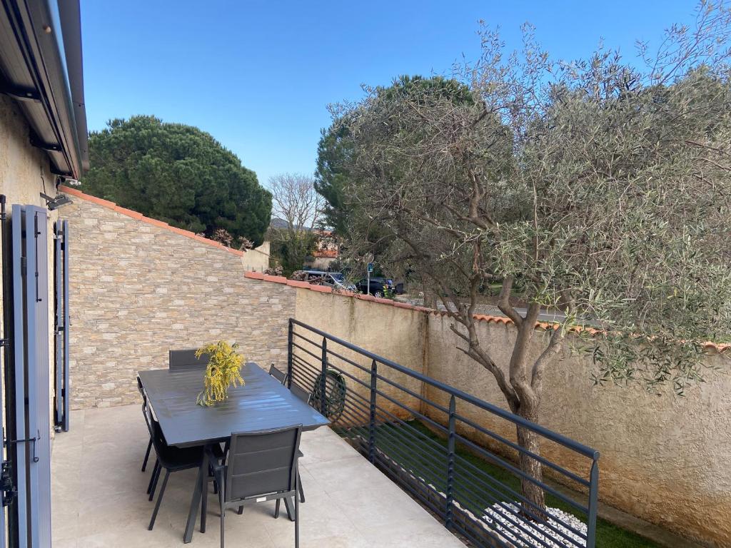 a table and chairs on a balcony with a tree at Maison la Londe in La Londe-les-Maures