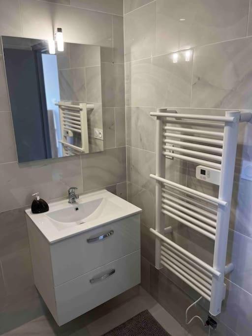 a white bathroom with a sink and a mirror at T1 dans une villa in Bagnols-sur-Cèze