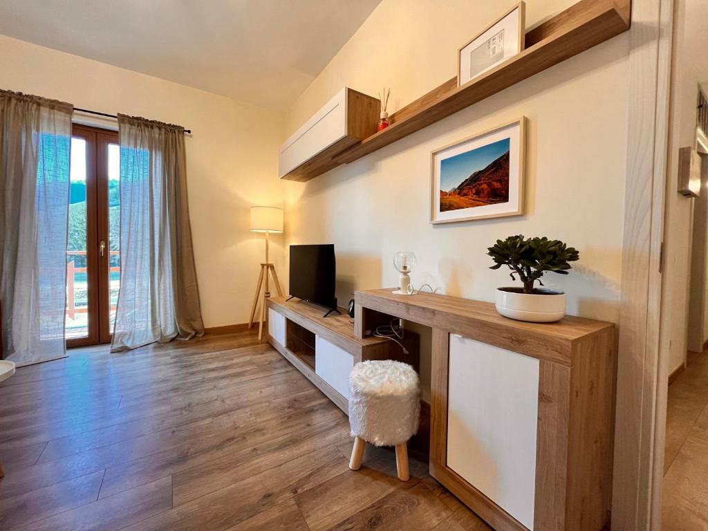 uma sala de estar com uma secretária e uma televisão em La casa del Mercato em Santa Maria Maggiore