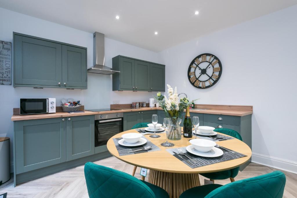 a kitchen with a wooden table and green cabinets at Rio's Retreat in Cottingham
