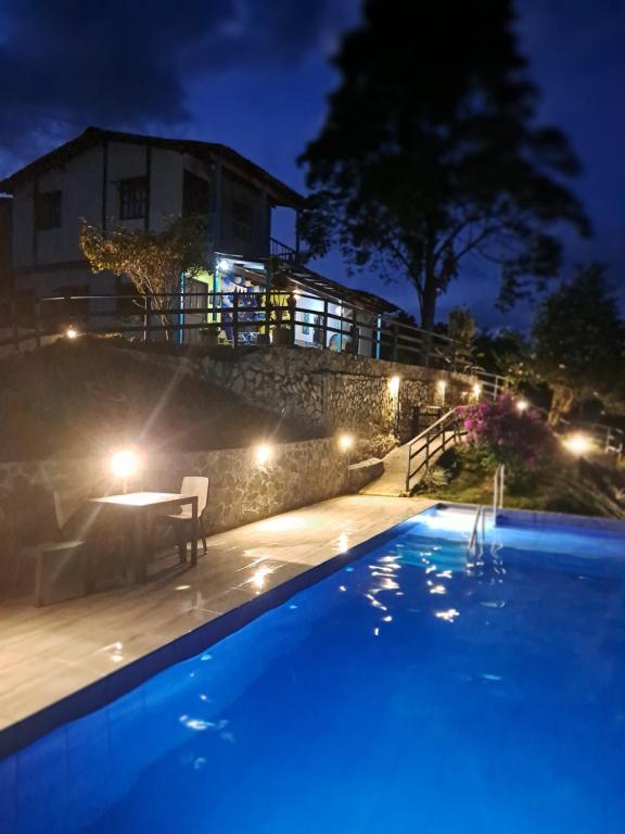 una piscina notturna con una casa sullo sfondo di Finca Hotel Palma de Iraka - Quindío - Hasta 26 Personas a La Tebaida