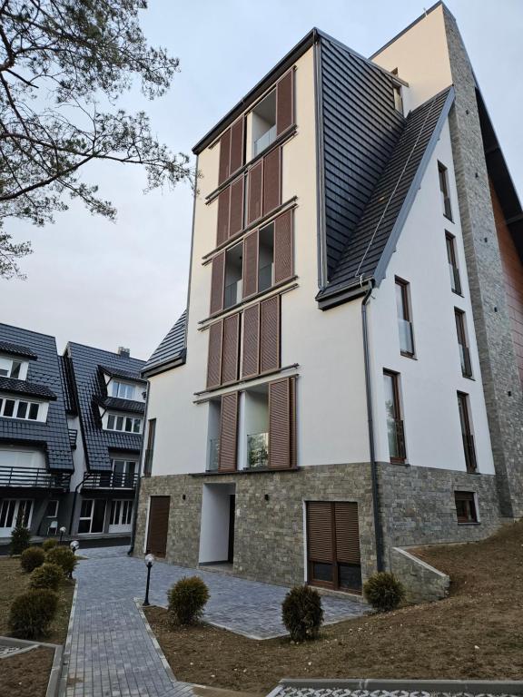 an apartment building with a black roof at Studio Apartman Nomad Divčibare in Divčibare