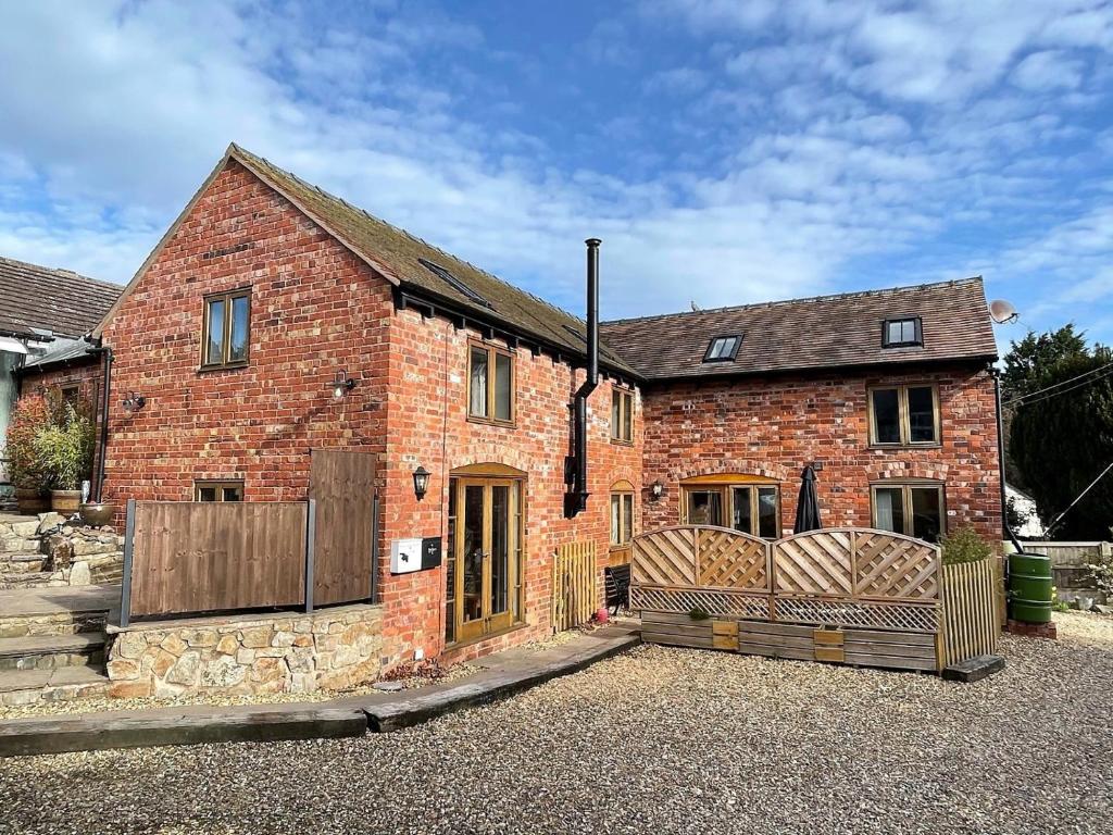 een rood bakstenen huis met een houten hek bij 4 Bed in Shrewsbury 50180 in Pontesbury