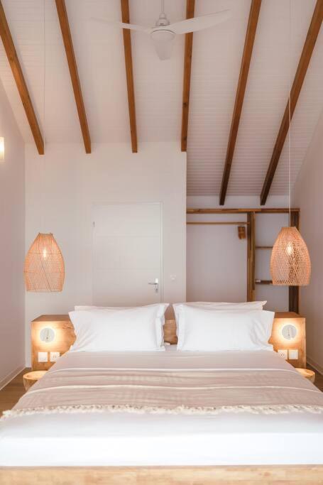 波尔兰特Vaneïa : Vue mer panoramique depuis un duplex d'exception的一间卧室配有一张带两盏灯的大型白色床。