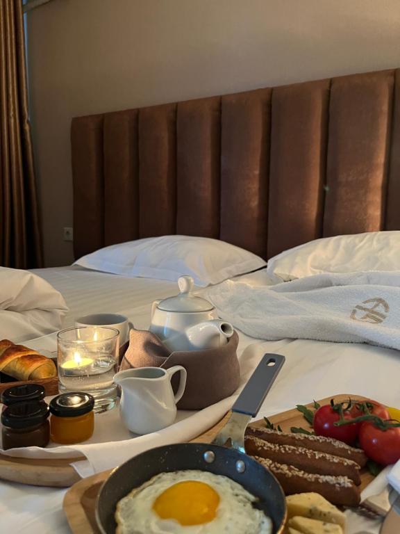 a breakfast tray with eggs and bread on a bed at Grand Hotel Kapan, Armenia in Kapan