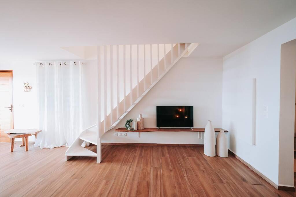 波尔兰特Vaneïa : Vue mer panoramique depuis un duplex d'exception的一间带电视和楼梯的客厅