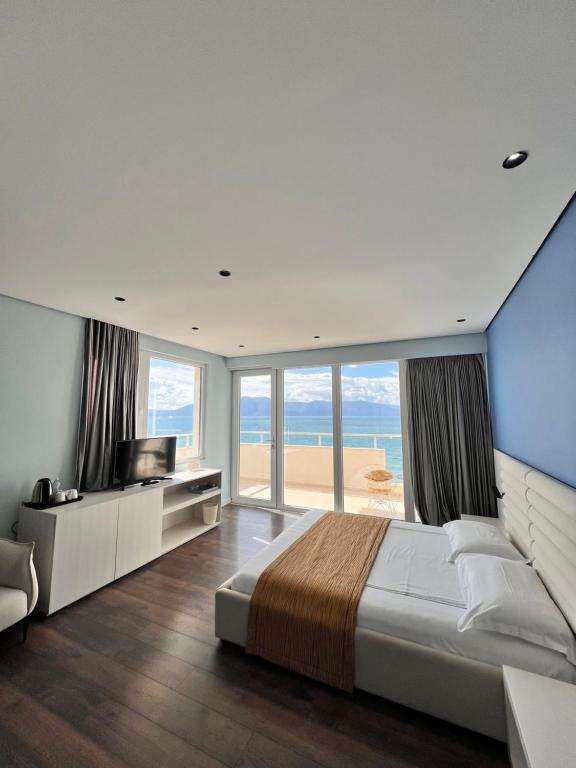 a bedroom with a large bed and a large window at Maxi Room in Vlorë