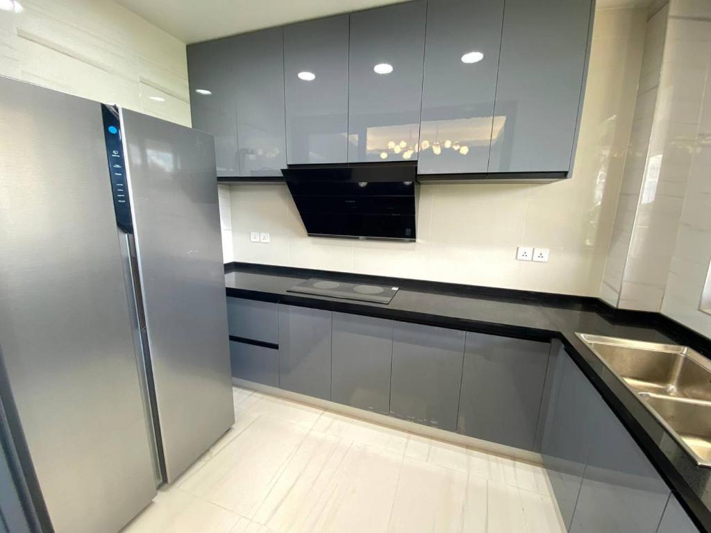 a kitchen with stainless steel cabinets and a sink at City One Apartments Kololo in Kampala