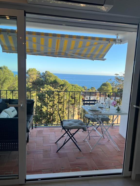 een glazen schuifdeur met uitzicht op de oceaan bij Azteka Blue 2 Bed Apartment Calella de Palafrugell in Calella de Palafrugell