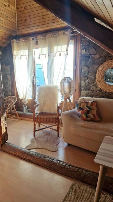 ein Wohnzimmer mit einem Sofa und einem Fenster in der Unterkunft Maison atypique au grand charme in Embrun