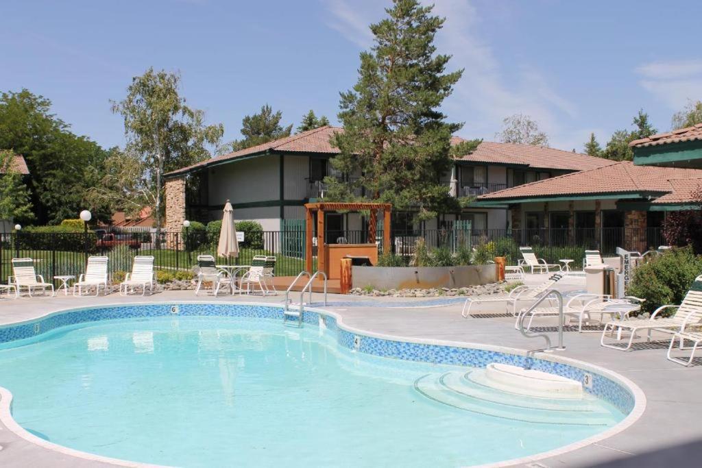 a swimming pool at a resort with chairs and a building at Thunderbird Resort Club in Reno